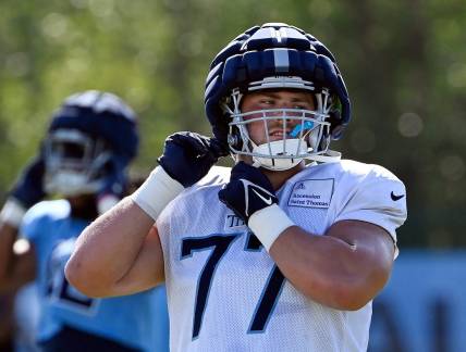 Tennessee Titans offensive tackle Peter Skoronski (77) puts on his helmet before an NFL football training camp practice Tuesday, August 1, 2023, in Nashville, Tenn.
