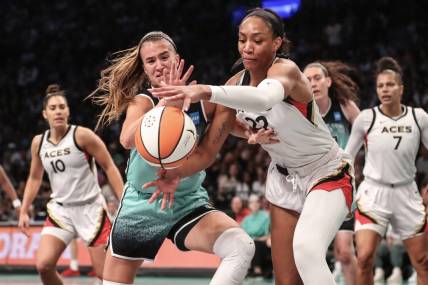 Aug 6, 2023; Brooklyn, New York, USA;  New York Liberty guard Sabrina Ionescu (20) and Las Vegas Aces forward A'ja Wilson (22) fight for a loose ball in the first quarter at Barclays Center. Mandatory Credit: Wendell Cruz-USA TODAY Sports