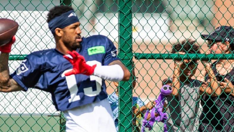 A young fan watches New England Patriots defensive back Jack Jones (13) from behind a fence at Clarke Hinkle Field during a joint practice with the Green Bay Packers in Ashwaubenon, Wis. on Thursday, August 17, 2023. Seeger Gray/USA TODAY NETWORK-Wisconsin