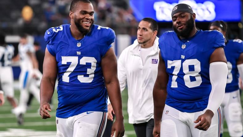 Aug 18, 2023; East Rutherford, New Jersey, USA; New York Giants offensive tackle Evan Neal (73) and New York Giants offensive tackle Andrew Thomas (78) exit the field after defeating the Carolina Panthers at MetLife Stadium. Mandatory Credit: John Jones-USA TODAY Sports