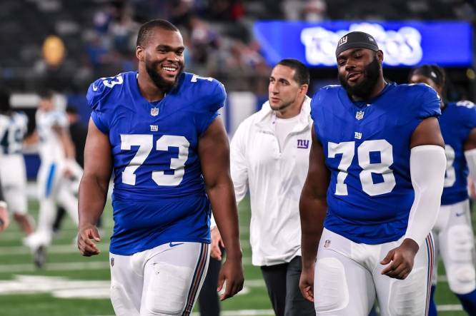 Aug 18, 2023; East Rutherford, New Jersey, USA; New York Giants offensive tackle Evan Neal (73) and New York Giants offensive tackle Andrew Thomas (78) exit the field after defeating the Carolina Panthers at MetLife Stadium. Mandatory Credit: John Jones-USA TODAY Sports