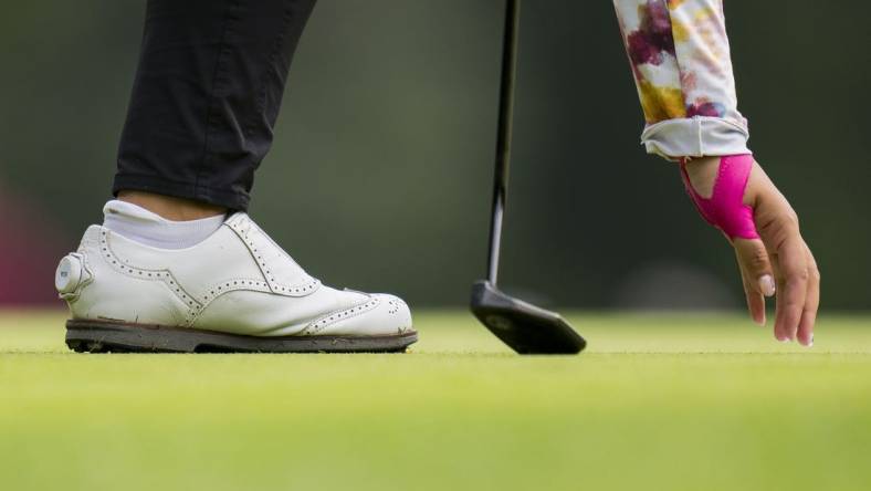 Aug 25, 2023; Vancouver, British Columbia, CAN; Lilia Vu picks her ball out of the hole on the sixth green during the second round of the CPKC Women's Open golf tournament at Shaughnessy Golf & Country Club. Mandatory Credit: Bob Frid-USA TODAY Sports