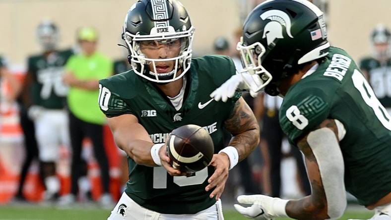 Sep 1, 2023; East Lansing, Michigan, USA;  Michigan State Spartans quarterback Noah Kim (10) hands the ball to Michigan State Spartans running back Jalen Berger (8) against the Central Michigan Chippewas at Spartan Stadium. Mandatory Credit: Dale Young-USA TODAY Sports