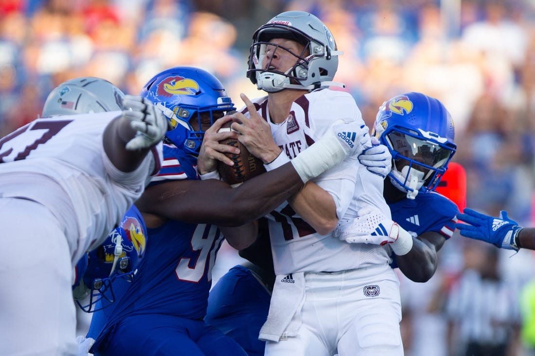 Kansas redshirt senior linebacker Tristian Fletcher (19) and junior defensive lineman Jereme Robinson (90) takes down Missouri State quarterback Jacob Clark (12) in the first quarter of Friday's game inside David Booth Kansas Memorial Stadium.