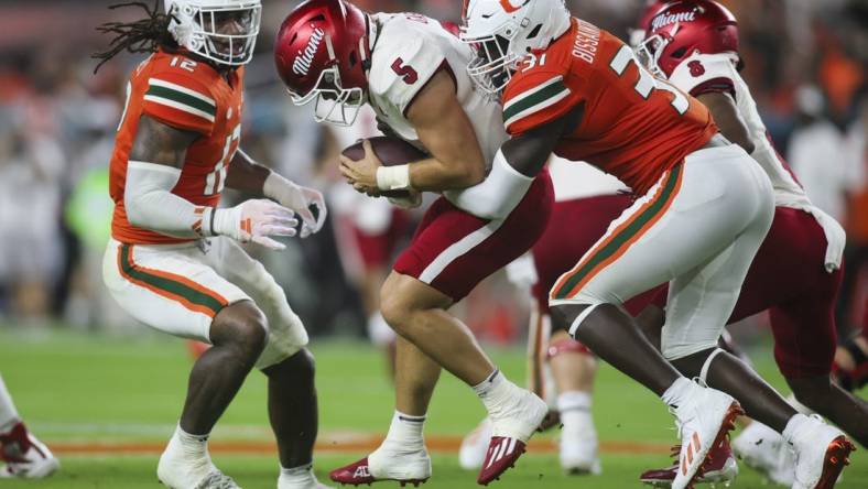 Sep 1, 2023; Miami Gardens, Florida, USA; Miami Hurricanes linebacker Wesley Bissainthe (31) sacks Miami Redhawks quarterback Brett Gabbert (5) during the second quarter at Hard Rock Stadium. Mandatory Credit: Sam Navarro-USA TODAY Sports