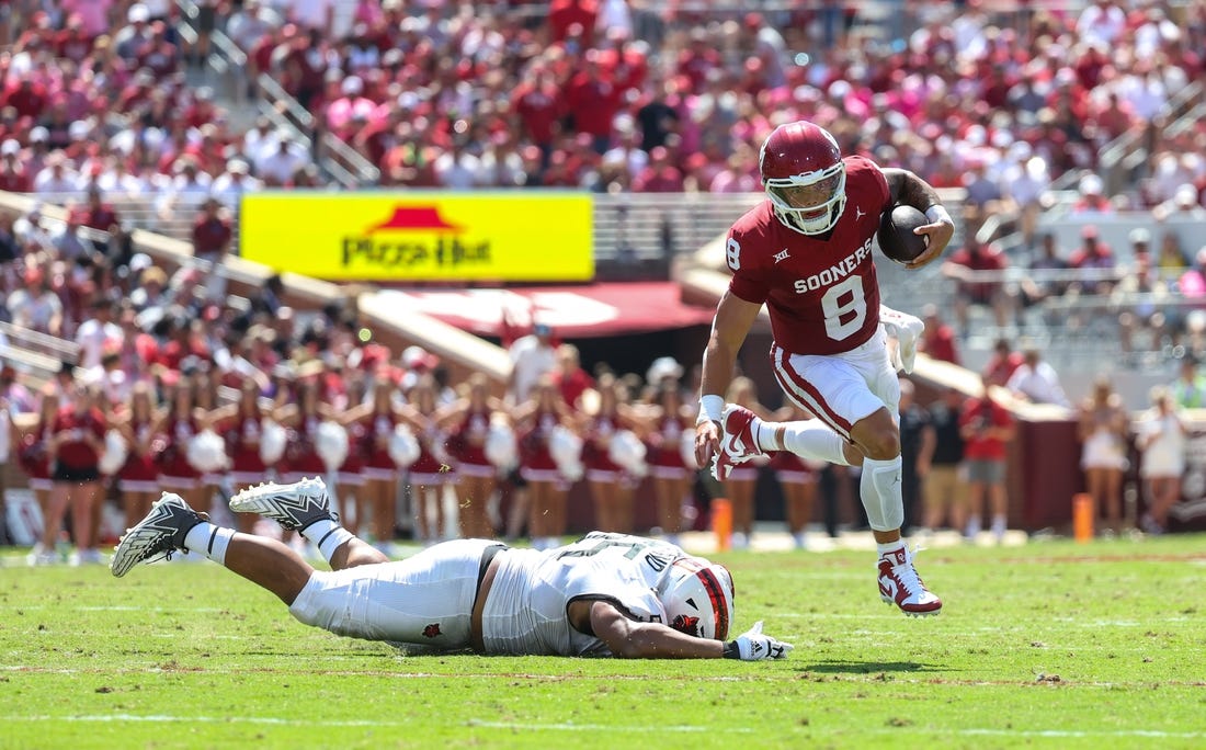 Sep 2, 2023; Norman, Oklahoma, USA; Oklahoma Sooners quarterback Dillon Gabriel (8) runs past Arkansas State Red Wolves defensive lineman Micah Bland (55) during the second quarter at Gaylord Family-Oklahoma Memorial Stadium. Mandatory Credit: Kevin Jairaj-USA TODAY Sports