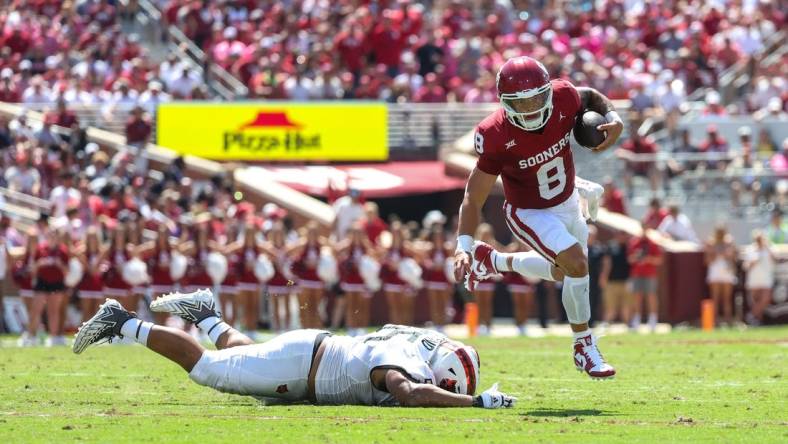 Sep 2, 2023; Norman, Oklahoma, USA; Oklahoma Sooners quarterback Dillon Gabriel (8) runs past Arkansas State Red Wolves defensive lineman Micah Bland (55) during the second quarter at Gaylord Family-Oklahoma Memorial Stadium. Mandatory Credit: Kevin Jairaj-USA TODAY Sports