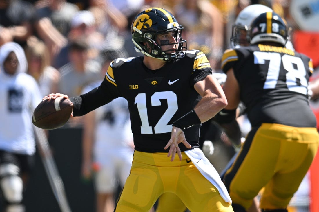 Sep 2, 2023; Iowa City, Iowa, USA; Iowa Hawkeyes quarterback Cade McNamara (12) throws a pass against the Utah State Aggies during the second quarter at Kinnick Stadium. Mandatory Credit: Jeffrey Becker-USA TODAY Sports