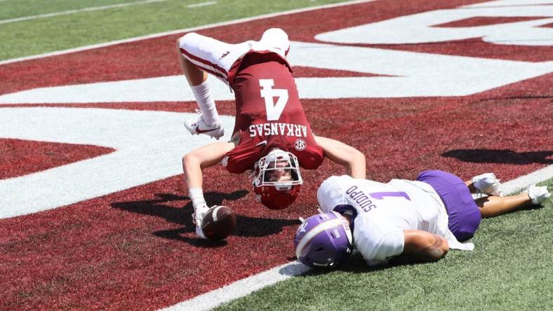 Sep 2, 2023; Little Rock, Arkansas, USA; Arkansas Razorbacks wide receiver Isaac TeSlaa (4) scores a touchdown in the first quarter as Western Carolina Catamounts safety Mateo Sudipo (1) defends at War Memorial Stadium. Mandatory Credit: Nelson Chenault-USA TODAY Sports