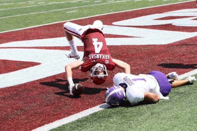 Sep 2, 2023; Little Rock, Arkansas, USA; Arkansas Razorbacks wide receiver Isaac TeSlaa (4) scores a touchdown in the first quarter as Western Carolina Catamounts safety Mateo Sudipo (1) defends at War Memorial Stadium. Mandatory Credit: Nelson Chenault-USA TODAY Sports