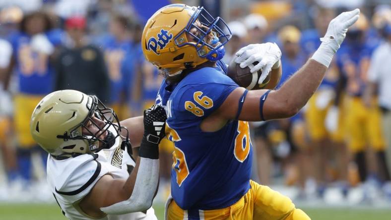 Sep 2, 2023; Pittsburgh, Pennsylvania, USA;  Pittsburgh Panthers tight end Gavin Bartholomew (86) makes a catch as Wofford Terriers linebacker David Powers (34) during the second quarter at Acrisure Stadium. Mandatory Credit: Charles LeClaire-USA TODAY Sports