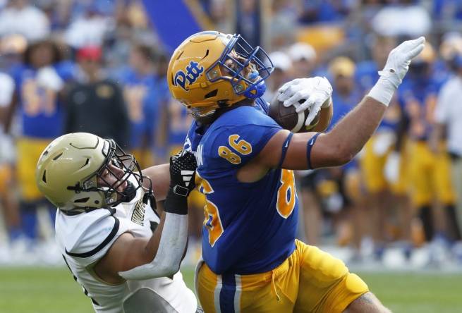 Sep 2, 2023; Pittsburgh, Pennsylvania, USA;  Pittsburgh Panthers tight end Gavin Bartholomew (86) makes a catch as Wofford Terriers linebacker David Powers (34) during the second quarter at Acrisure Stadium. Mandatory Credit: Charles LeClaire-USA TODAY Sports