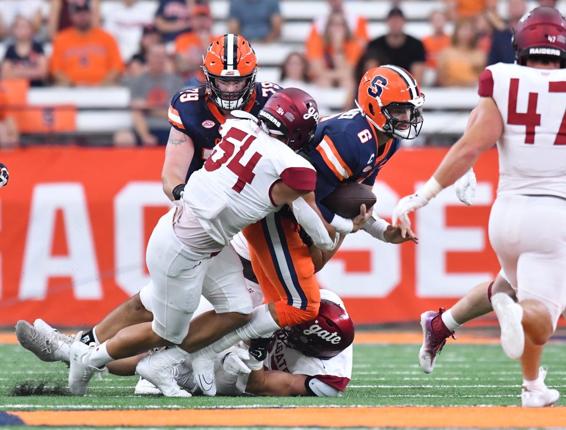 Sep 2, 2023; Syracuse, New York, USA; Syracuse Orange quarterback Garrett Shrader (6) is tackled by Colgate Raiders linebacker Christian Sweeney (54) in the first quarter at JMA Wireless Dome. Mandatory Credit: Mark Konezny-USA TODAY Sports