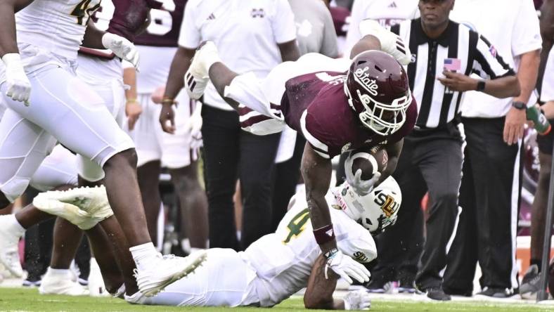 Sep 2, 2023; Starkville, Mississippi, USA; Mississippi State Bulldogs running back Jo'Quavious Marks (7) dives over Southeastern Louisiana Lions defensive back Ian Goodly (4) during the second quarter at Davis Wade Stadium at Scott Field. Mandatory Credit: Matt Bush-USA TODAY Sports