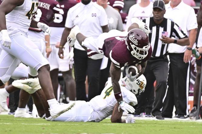 Sep 2, 2023; Starkville, Mississippi, USA; Mississippi State Bulldogs running back Jo'Quavious Marks (7) dives over Southeastern Louisiana Lions defensive back Ian Goodly (4) during the second quarter at Davis Wade Stadium at Scott Field. Mandatory Credit: Matt Bush-USA TODAY Sports
