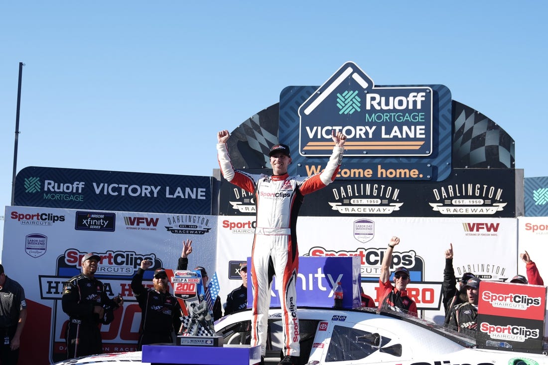 Sep 2, 2023; Darlington, South Carolina, USA; NASCAR Xfinity Series driver Denny Hamlin (19) celebrates in Victory Lane after winning the NASCAR Xfinity Series Sport Clips Haircuts VFW Help A Hero 200 at Darlington Raceway. Mandatory Credit: David Yeazell-USA TODAY Sports