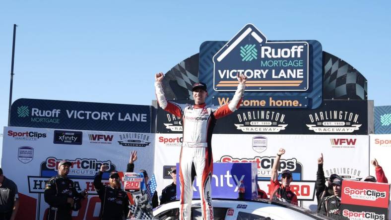 Sep 2, 2023; Darlington, South Carolina, USA; NASCAR Xfinity Series driver Denny Hamlin (19) celebrates in Victory Lane after winning the NASCAR Xfinity Series Sport Clips Haircuts VFW Help A Hero 200 at Darlington Raceway. Mandatory Credit: David Yeazell-USA TODAY Sports