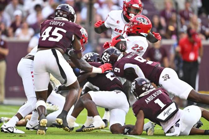 Sep 2, 2023; College Station, Texas, USA; New Mexico Lobos running back Christian Washington (22) is tackled during the second quarter against the Texas A&M Aggies at Kyle Field. Mandatory Credit: Maria Lysaker-USA TODAY Sports