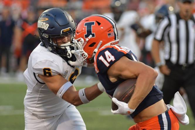 Sep 2, 2023; Champaign, Illinois, USA;  Toledo Rockets safety Nate Bauer (6) tries to tackle Illinois Fighting Illini wide receiver Casey Washington (14) during the first half at Memorial Stadium. Mandatory Credit: Ron Johnson-USA TODAY Sports