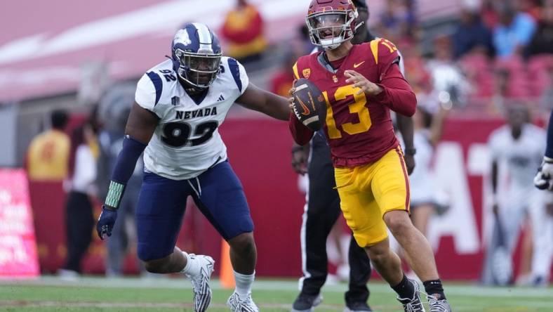 Sep 2, 2023; Los Angeles, California, USA; Southern California Trojans quarterback Caleb Williams (13) is pressured by Nevada Wolf Pack defensive end Dion Washington (92) in the second half at United Airlines Field at Los Angeles Memorial Coliseum. Mandatory Credit: Kirby Lee-USA TODAY Sports