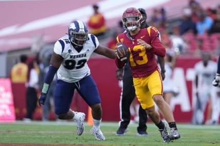 Sep 2, 2023; Los Angeles, California, USA; Southern California Trojans quarterback Caleb Williams (13) is pressured by Nevada Wolf Pack defensive end Dion Washington (92) in the second half at United Airlines Field at Los Angeles Memorial Coliseum. Mandatory Credit: Kirby Lee-USA TODAY Sports