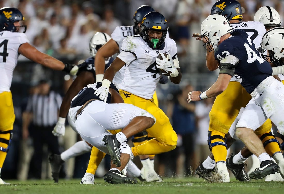 Sep 2, 2023; University Park, Pennsylvania, USA; West Virginia Mountaineers running back CJ Donaldson Jr. (4) runs the ball against the Penn State Nittany Lions during the fourth quarter at Beaver Stadium. Penn State won 38-15. Mandatory Credit: Matthew O'Haren-USA TODAY Sports