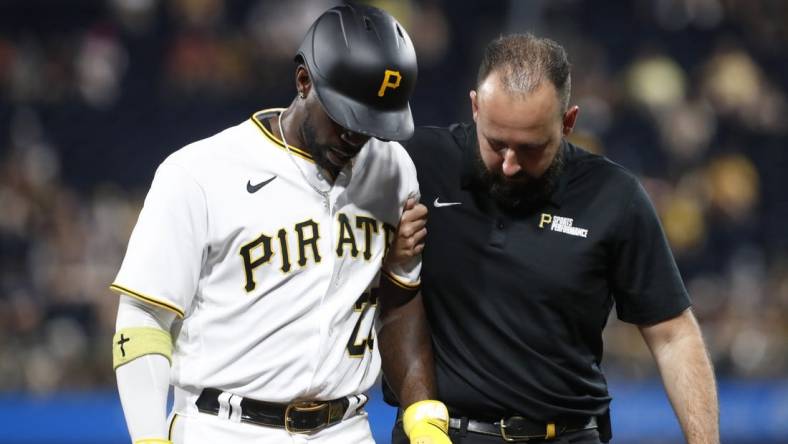 Sep 4, 2023; Pittsburgh, Pennsylvania, USA;  Pittsburgh Pirates designated hitter Andrew McCutchen (22) is helped from the field after suffering an apparent injury against the Milwaukee Brewers during the fifth inning at PNC Park. Mandatory Credit: Charles LeClaire-USA TODAY Sports