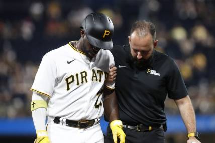 Sep 4, 2023; Pittsburgh, Pennsylvania, USA;  Pittsburgh Pirates designated hitter Andrew McCutchen (22) is helped from the field after suffering an apparent injury against the Milwaukee Brewers during the fifth inning at PNC Park. Mandatory Credit: Charles LeClaire-USA TODAY Sports