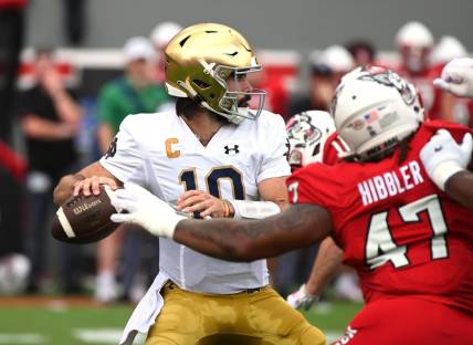 Sep 9, 2023; Raleigh, North Carolina, USA; Notre Dame Fighting Irish quarterback Sam Hartman (10) looks to pass as he is pressured by North Carolina State Wolfpack defensive lineman Jykeveous Red Hibbler(47) during the first half  at Carter-Finley Stadium. Mandatory Credit: Rob Kinnan-USA TODAY Sports