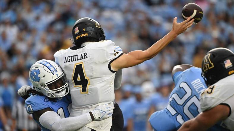 Sep 9, 2023; Chapel Hill, North Carolina, USA; Appalachian State Mountaineers quarterback Joey Aguilar (4) passes the ball as North Carolina Tar Heels defensive lineman Desmond Evans (10) pressures in the second quarter at Kenan Memorial Stadium. Mandatory Credit: Bob Donnan-USA TODAY Sports