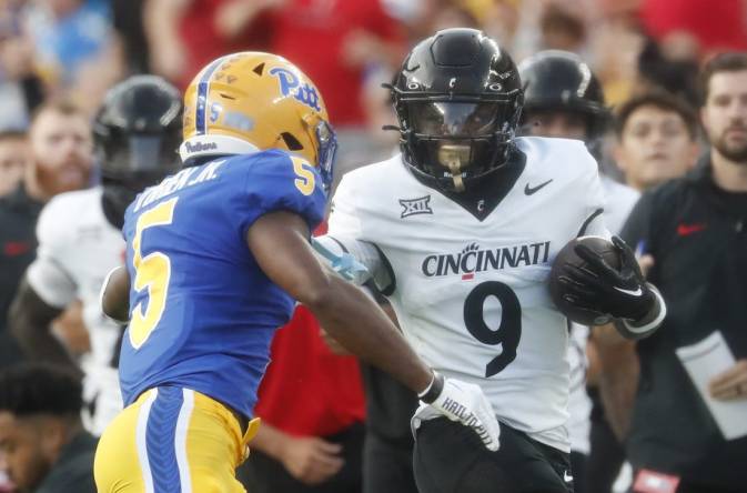 Sep 9, 2023; Pittsburgh, Pennsylvania, USA; Cincinnati Bearcats wide receiver Aaron Turner (9) carries the ball on an end around as Pittsburgh Panthers defensive back Phillip O'Brien Jr. (5) chases during the first quarter at Acrisure Stadium. Mandatory Credit: Charles LeClaire-USA TODAY Sports