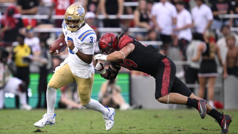 Sep 9, 2023; San Diego, California, USA; UCLA Bruins quarterback Dante Moore (3) runs the ball while defended by San Diego State Aztecs defensive lineman Garret Fountain (39) during the first half at Snapdragon Stadium. Mandatory Credit: Orlando Ramirez-USA TODAY Sports