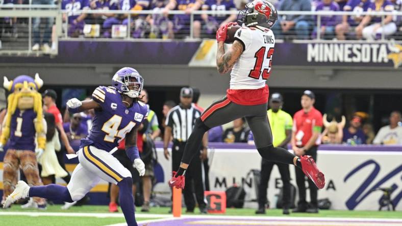 Sep 10, 2023; Minneapolis, Minnesota, USA; Tampa Bay Buccaneers wide receiver Mike Evans (13) catches a touchdown pass from quarterback Baker Mayfield (not pictured) as Minnesota Vikings safety Josh Metellus (44) defends during the second quarter at U.S. Bank Stadium. Mandatory Credit: Jeffrey Becker-USA TODAY Sports