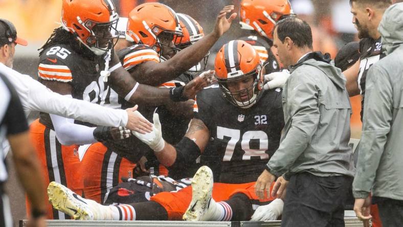 Sep 10, 2023; Cleveland, Ohio, USA; Cleveland Browns offensive tackle Jack Conklin (78) gets support from his teammates following an injury during the first half at Cleveland Browns Stadium. Mandatory Credit: Scott Galvin-USA TODAY Sports