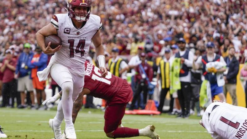 Sep 10, 2023; Landover, Maryland, USA; Washington Commanders quarterback Sam Howell (14) rushes for a touchdown against the Arizona Cardinals during the 4th quarter at FedExField. Mandatory Credit: Brent Skeen-USA TODAY Sports