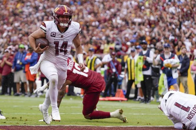 Sep 10, 2023; Landover, Maryland, USA; Washington Commanders quarterback Sam Howell (14) rushes for a touchdown against the Arizona Cardinals during the 4th quarter at FedExField. Mandatory Credit: Brent Skeen-USA TODAY Sports