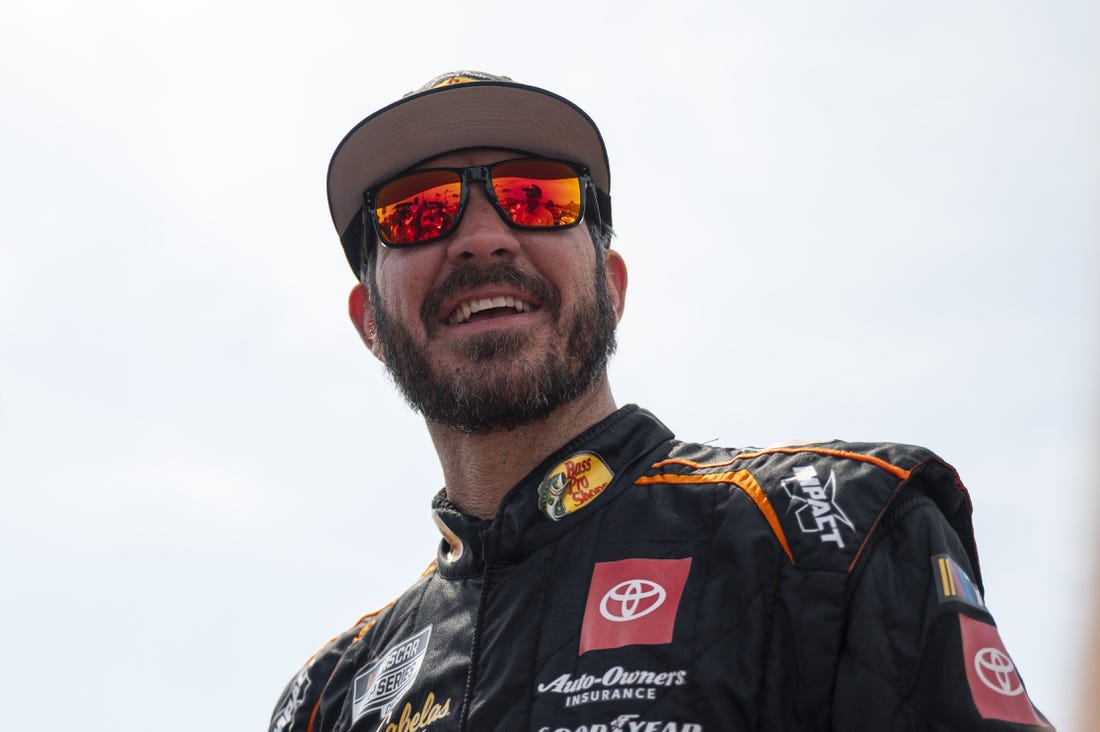 Sep 10, 2023; Kansas City, Kansas, USA; NASCAR Cup Series driver Martin Truex Jr. (19) smiles on the grid before the NASCAR Cup Series Hollywood Casino 400 at Kansas Speedway. Mandatory Credit: Amy Kontras-USA TODAY Sports