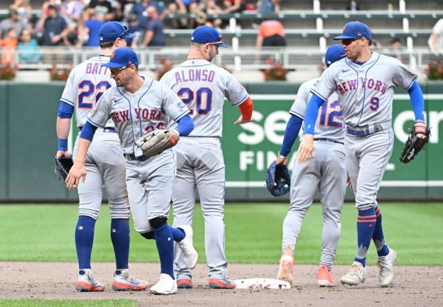 Sep 10, 2023; Minneapolis, Minnesota, USA; New York Mets left fielder Tim Locastro (26) and New York Mets center fielder Brandon Nimmo (9) celebrate a 2-0 win with their teammates at Target Field. Mandatory Credit: Michael McLoone-USA TODAY Sports
