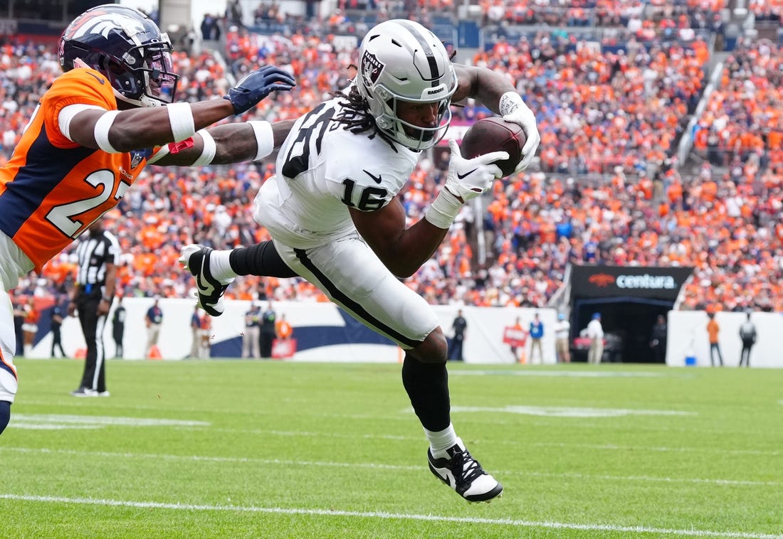 Sep 10, 2023; Denver, Colorado, USA;  Las Vegas Raiders wide receiver Jakobi Meyers (16) catches a touchdown pass with Denver Broncos cornerback Damarri Mathis (27) defending in the first quarter at Empower Field at Mile High. Mandatory Credit: Ron Chenoy-USA TODAY Sports