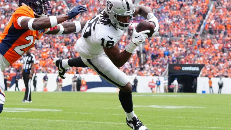 Sep 10, 2023; Denver, Colorado, USA;  Las Vegas Raiders wide receiver Jakobi Meyers (16) catches a touchdown pass with Denver Broncos cornerback Damarri Mathis (27) defending in the first quarter at Empower Field at Mile High. Mandatory Credit: Ron Chenoy-USA TODAY Sports