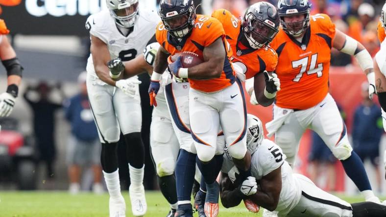 Sep 10, 2023; Denver, Colorado, USA; Las Vegas Raiders linebacker Divine Deablo (5) tackles Denver Broncos running back Samaje Perine (25) in the second quarter at Empower Field at Mile High. Mandatory Credit: Ron Chenoy-USA TODAY Sports