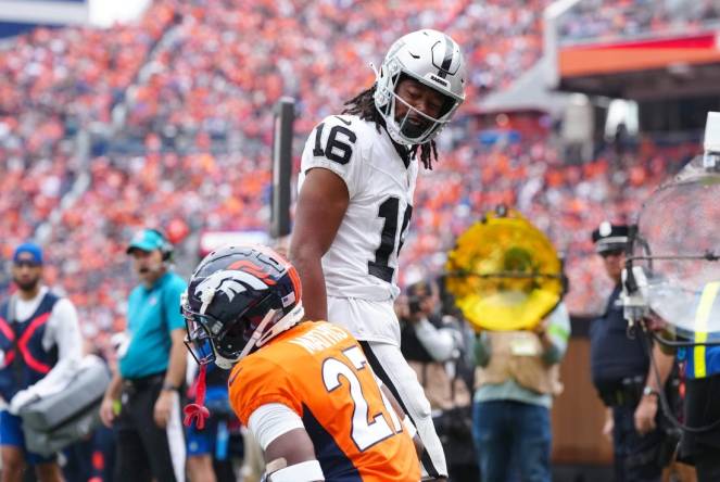 Sep 10, 2023; Denver, Colorado, USA; Las Vegas Raiders wide receiver Jakobi Meyers (16) reacts towards Denver Broncos cornerback Damarri Mathis (27) following his touchdown reception in the first quarter at Empower Field at Mile High. Mandatory Credit: Ron Chenoy-USA TODAY Sports