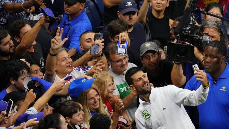 Sep 10, 2023; Flushing, NY, USA; Novak Djokovic of Serbia takes a selfie with fans after his match against Daniil Medvedev (not pictured) in the men's singles final in the men's singles final on day fourteen of the 2023 U.S. Open tennis tournament at USTA Billie Jean King National Tennis Center. Mandatory Credit: Danielle Parhizkaran-USA TODAY Sports
