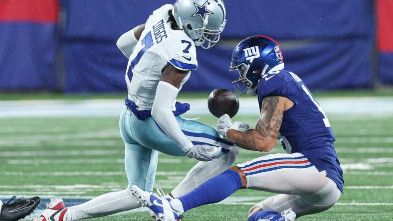 Sep 10, 2023; East Rutherford, New Jersey, USA; Dallas Cowboys cornerback Trevon Diggs (7) forces a fumble by New York Giants wide receiver Isaiah Hodgins (18) during the second half at MetLife Stadium. Mandatory Credit: Vincent Carchietta-USA TODAY Sports