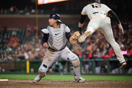 Sep 11, 2023; San Francisco, California, USA; San Francisco Giants outfielder Austin Slater (13) leaps after being tagged out by Cleveland Guardians catcher Bo Naylor (23) on a force play at home plate during the seventh inning at Oracle Park. Mandatory Credit: Robert Edwards-USA TODAY Sports