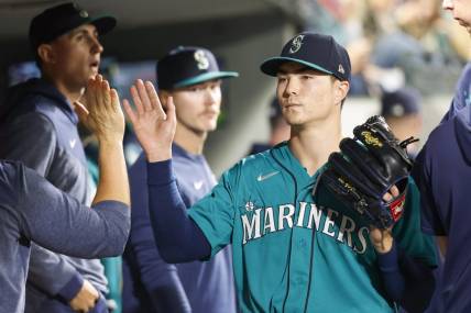 Sep 12, 2023; Seattle, Washington, USA; Seattle Mariners starting pitcher Bryan Woo (33) high-fives teammates and staff in the dugout during a sixth inning pitching change against the Los Angeles Angels at T-Mobile Park. Mandatory Credit: Joe Nicholson-USA TODAY Sports