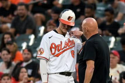 Sep 13, 2023; Baltimore, Maryland, USA;  Baltimore Orioles first baseman Ryan Mountcastle (6) reacts as trainer Brian Ebel examines his shoulder during the first inning against the St. Louis Cardinals at Oriole Park at Camden Yards. Mandatory Credit: Tommy Gilligan-USA TODAY Sports
