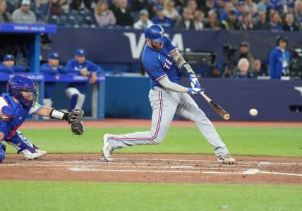 Sep 13, 2023; Toronto, Ontario, CAN; Texas Rangers catcher Jonah Heim (28) hits an RBI single against the Toronto Blue Jays during the fourth inning at Rogers Centre. Mandatory Credit: Nick Turchiaro-USA TODAY Sports