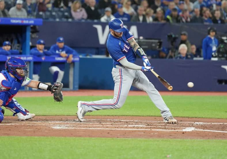 Sep 13, 2023; Toronto, Ontario, CAN; Texas Rangers catcher Jonah Heim (28) hits an RBI single against the Toronto Blue Jays during the fourth inning at Rogers Centre. Mandatory Credit: Nick Turchiaro-USA TODAY Sports