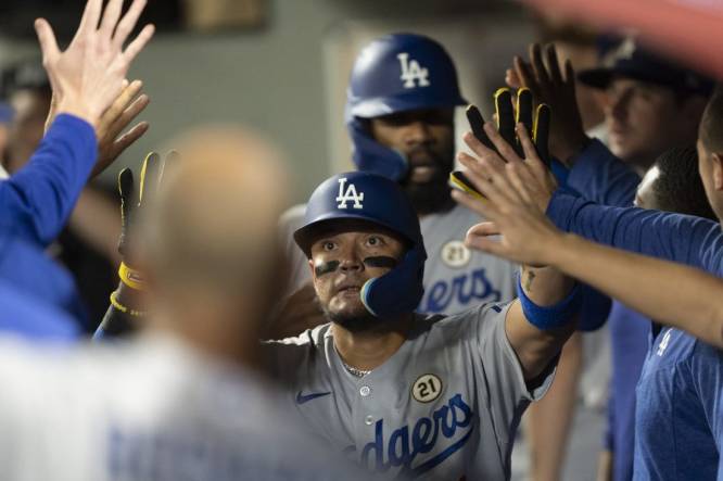 Sep 15, 2023; Seattle, Washington, USA; Los Angeles Dodgers shortstop Miguel Rojas (11) is congratulated by teammates in the dugout after hitting a two-run home run against the Seattle Mariners at T-Mobile Park. Mandatory Credit: Stephen Brashear-USA TODAY Sports